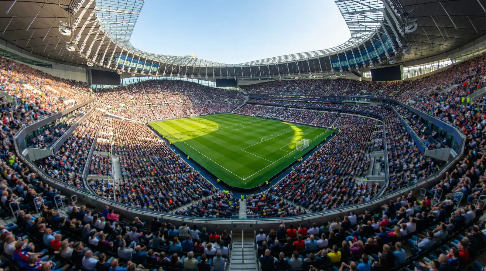 Panoramisch uitzicht over een vol voetbalstadion met groen veld en tribunes tijdens een WK-wedstrijd